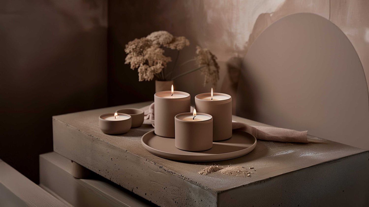 Bougies parfumées artisanales en cire, disposées sur un plateau décoratif avec contenants en céramique, dans une ambiance douce et chaleureuse.