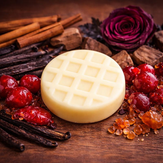 Fondant parfumé artisanal Fruit Défendu en cire d’olive, entouré de cerises confites, cannelle et rose noire dans une ambiance orientale et épicée chaleureuse.