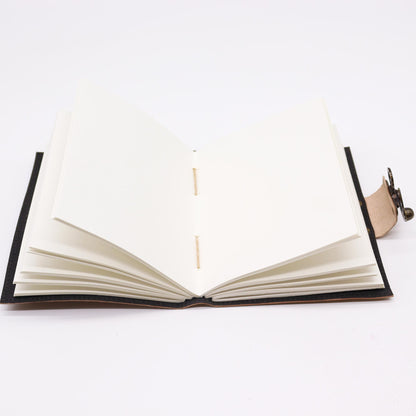 cahier en cuir ouvert sur des pages blanches